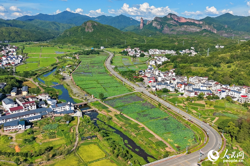 蜿蜒的柏油公路猶如銀龍穿行翠綠山間，與村庄、農田、山巒、河流相映成趣，構成一幅路暢通、景色美的夏日鄉村畫卷。人民網記者 朱海鵬攝
