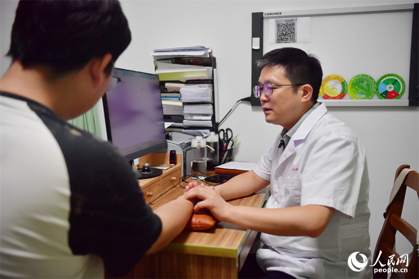 三伏貼貼敷前，醫生為市民把脈。人民網記者 時雨攝
