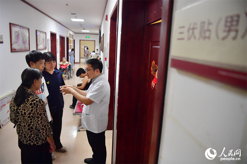 医生为市民们讲述三伏贴贴敷的功效和注意事项。人民网记者 时雨摄
