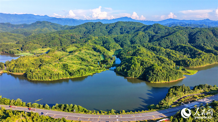 石城县龙岗乡旺龙湖,群山叠翠、碧水蜿蜒,连片的山林与农房、道路相互映衬,构成一幅夏日山水乡村生态画卷。人民网记者 朱海鹏摄