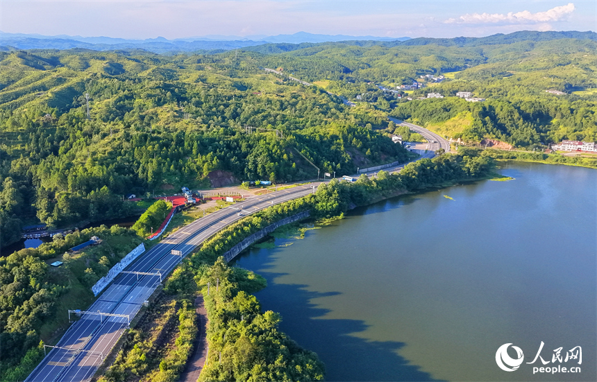 石城县龙岗乡旺龙湖，群山叠翠、碧水蜿蜒，连片的山林与农房、道路相互映衬，构成一幅夏日山水乡村生态画卷。人民网记者 朱海鹏摄