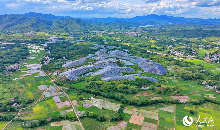 信丰县正平镇的农光互补光伏发电基地，鳞次栉比的太阳能光伏板与绵延青山、广袤沃野相映成景，美不胜收。人民网记者 朱海鹏摄