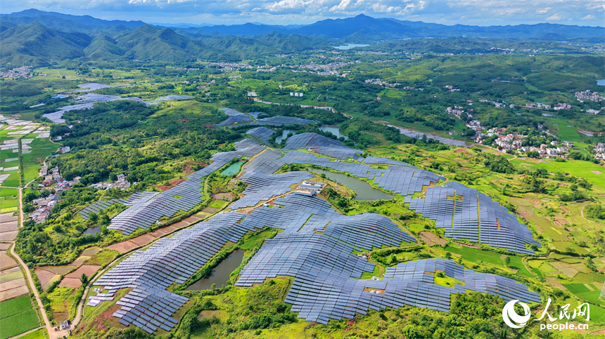 信丰县正平镇的农光互补光伏发电基地，鳞次栉比的太阳能光伏板与绵延青山、广袤沃野相映成景，美不胜收。人民网记者 朱海鹏摄