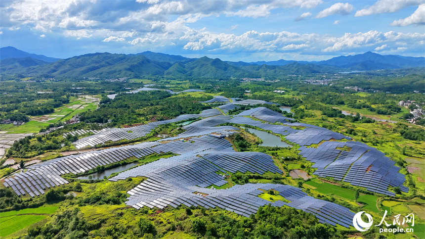 信丰县正平镇的农光互补光伏发电基地，鳞次栉比的太阳能光伏板与绵延青山、广袤沃野相映成景，美不胜收。人民网记者 朱海鹏摄
