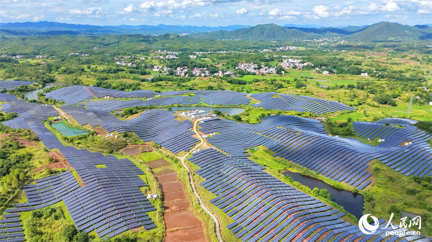 信丰县正平镇的农光互补光伏发电基地，鳞次栉比的太阳能光伏板与绵延青山、广袤沃野相映成景，美不胜收。人民网记者 朱海鹏摄