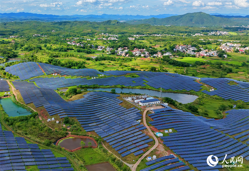 信丰县正平镇的农光互补光伏发电基地，鳞次栉比的太阳能光伏板与绵延青山、广袤沃野相映成景，美不胜收。人民网记者 朱海鹏摄