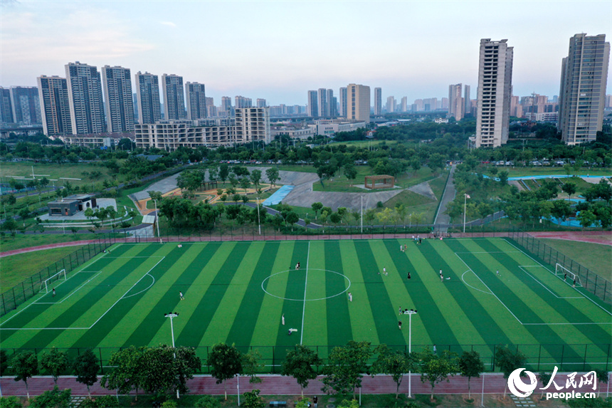 足球场上，市民正在踢球运动。人民网记者 时雨摄