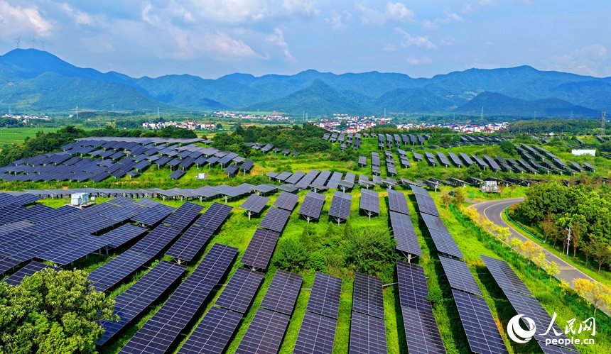 九江市湖口縣武山鎮王常村，連片的光伏發電板分布在林間空地上，與村庄沃野、山巒田疇交相輝映。人民網記者 朱海鵬攝