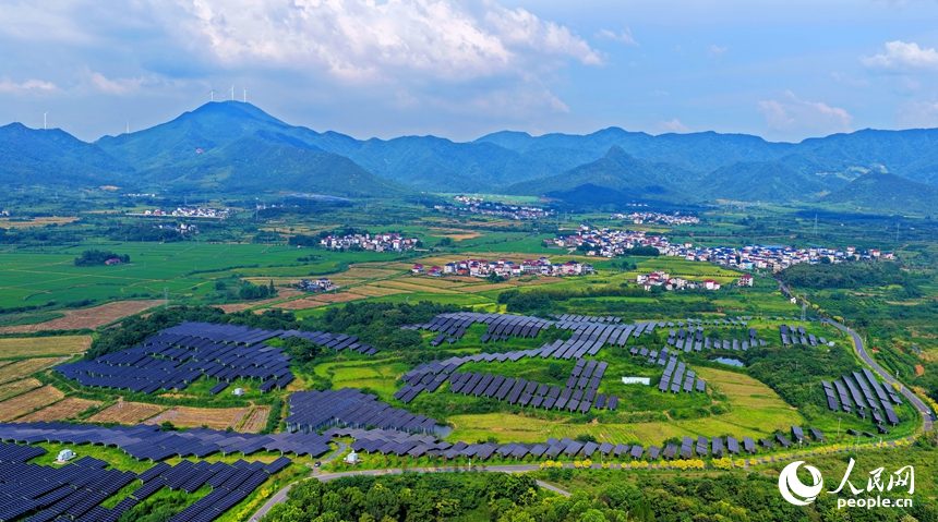 九江市湖口县武山镇王常村，连片的光伏发电板分布在林间空地上，与村庄沃野、山峦田畴交相辉映。人民网记者 朱海鹏摄