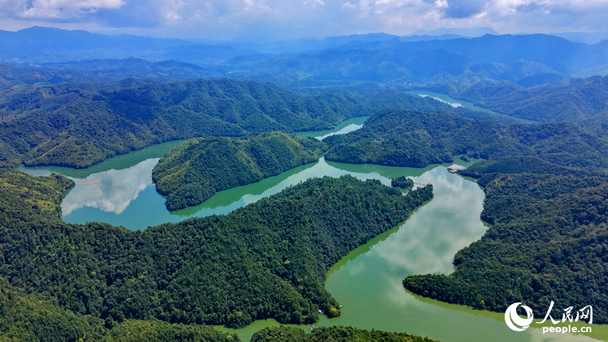 陽明湖國家濕地公園水域，樹木蔥郁、河流蜿蜒，與藍天白雲、蒼翠青山相映成景，勾勒出一幅水清岸綠的濕地生態畫卷。人民網記者 朱海鵬攝