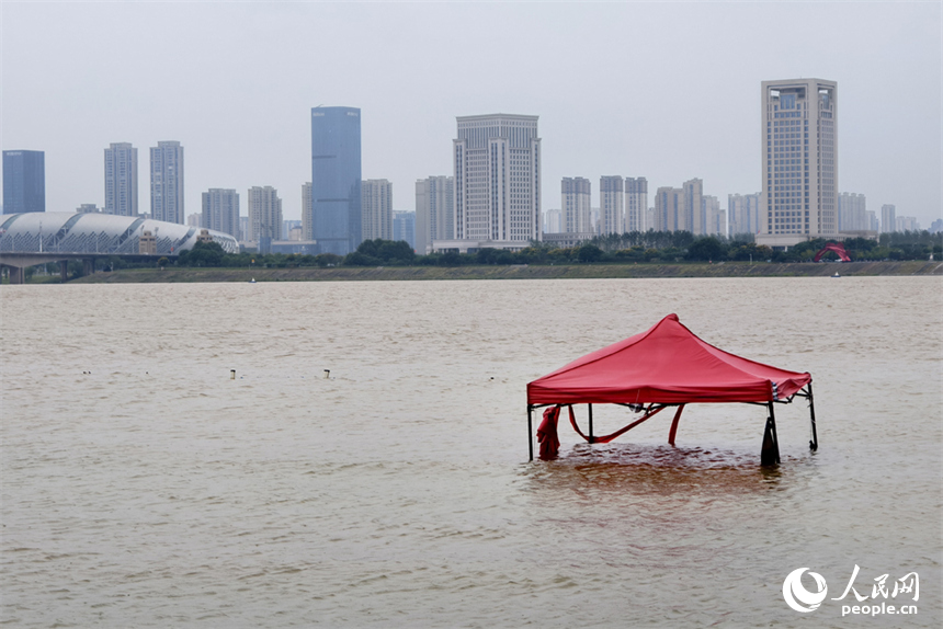 水位上涨，赣江边一顶遮阳篷被淹在水中。人民网记者 时雨摄