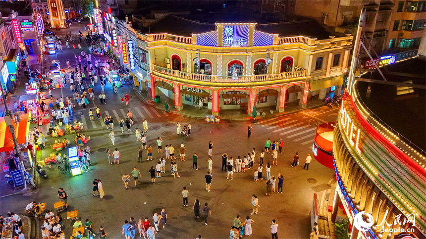 赣州市城区阳明路标准钟夜市街灯火璀璨，游客漫步老街，挑选文创手作，品尝特色小吃、观看非遗展演，畅享夜间消费休闲时光。人民网记者 朱海鹏摄