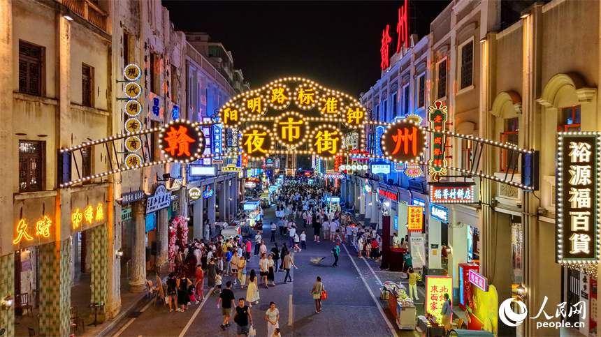赣州市城区阳明路标准钟夜市街灯火璀璨，游客漫步老街，挑选文创手作，品尝特色小吃、观看非遗展演，畅享夜间消费休闲时光。人民网记者 朱海鹏摄