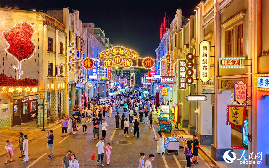 赣州市城区阳明路标准钟夜市街灯火璀璨，游客漫步老街，挑选文创手作，品尝特色小吃、观看非遗展演，畅享夜间消费休闲时光。人民网记者 朱海鹏摄