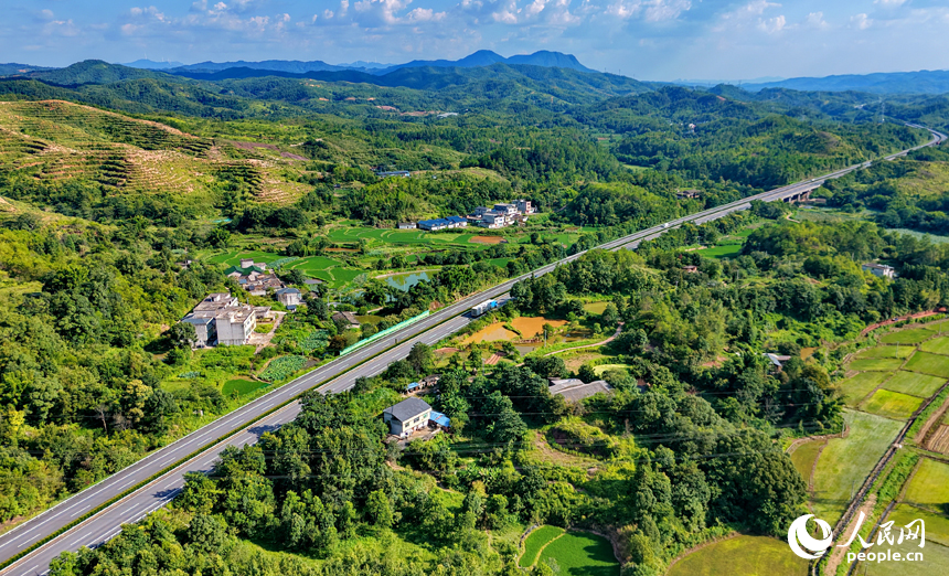 济广高速公路车辆疾驰而过，蜿蜒的公路与田园、农房相映成景。人民网记者 朱海鹏摄