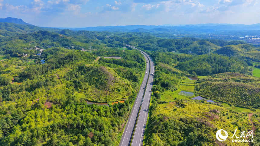 济广高速公路车辆疾驰而过，蜿蜒的公路与田园、农房相映成景。人民网记者 朱海鹏摄
