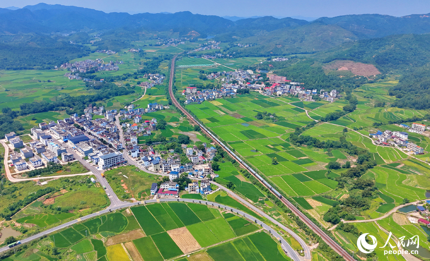 赣州市信丰县西牛镇黄泥村，旅客列车行驶在京九铁路线上。人民网记者 朱海鹏摄