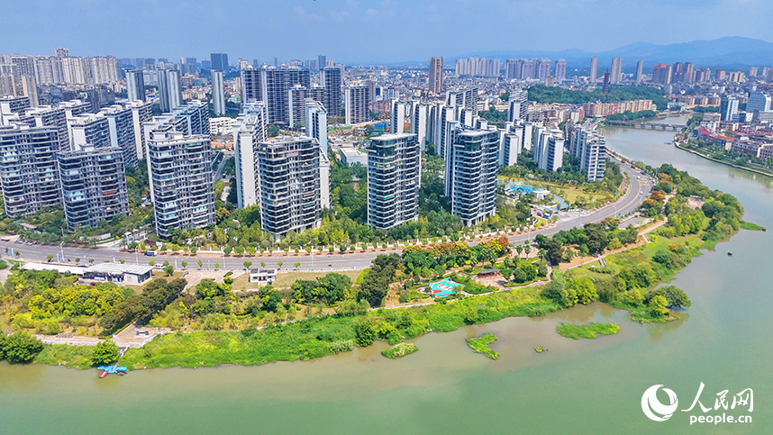 赣州市南康区章江江畔树木繁茂、色彩斑斓，与蓝天白云、城市建筑相映生辉，勾勒成一幅城水相融、生态秀丽的秋景画卷。人民网记者 朱海鹏摄