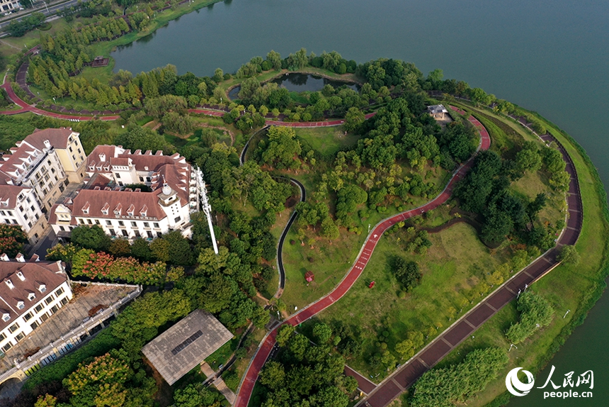 红谷滩区九龙湖沿岸依旧绿意葱茏，湖畔步道蜿蜒延伸，构成一幅城水相依的生态画卷。人民网记者 时雨摄