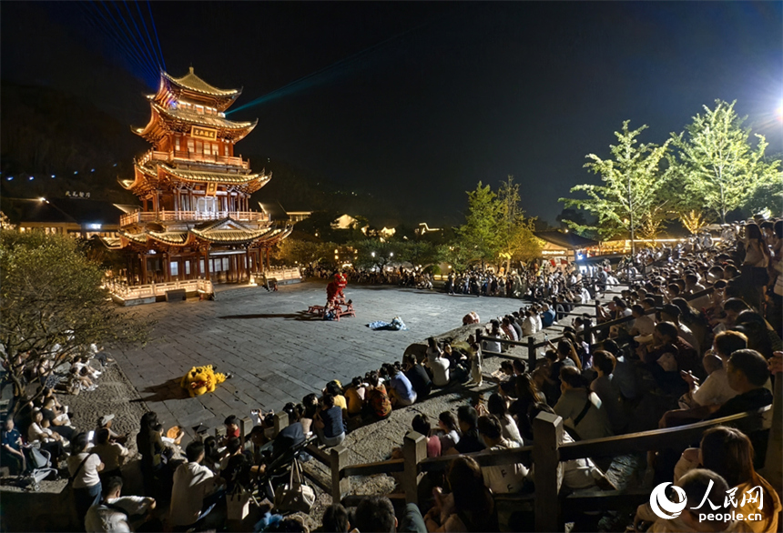 广场上，游客们观看舞狮表演。人民网记者 时雨摄