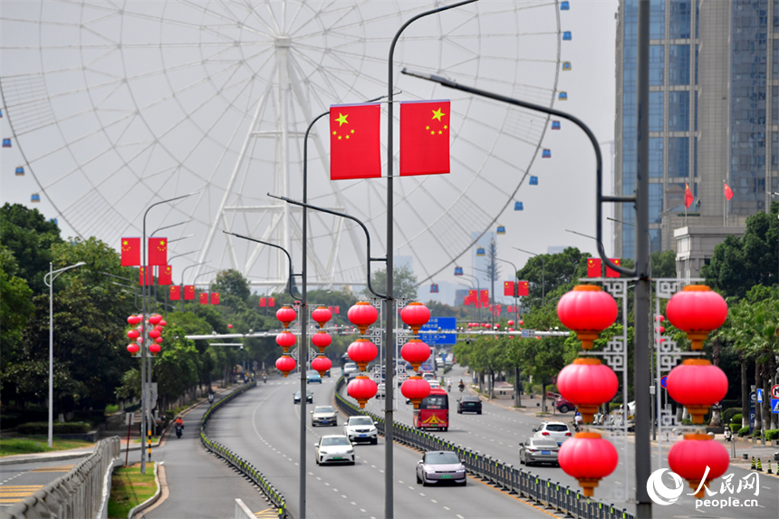 南昌市紅谷灘區的道路兩側懸挂著嶄新的國旗，城市洋溢著喜慶祥和的節日氛圍。人民網記者 時雨攝