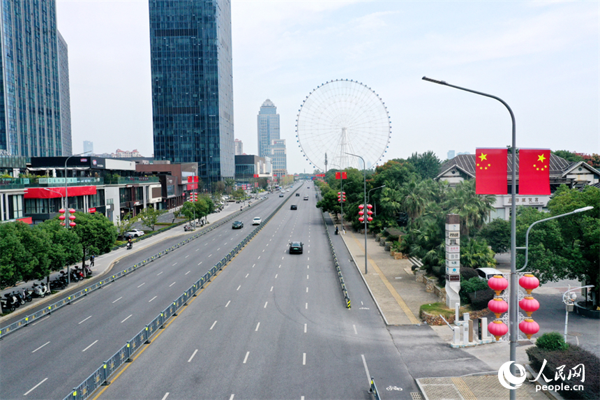 南昌市紅谷灘區的道路兩側懸挂著嶄新的國旗，城市洋溢著喜慶祥和的節日氛圍。人民網記者 時雨攝