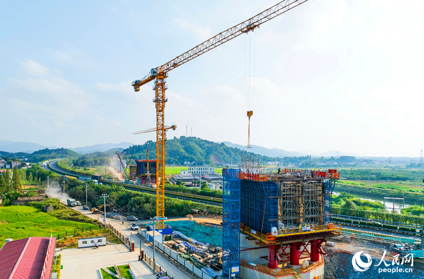 萍鄉市上栗縣金山鎮的栗水河特大橋建設現場，塔吊林立，工業作業繁忙，基樁澆筑有序推進。人民網記者 朱海鵬攝