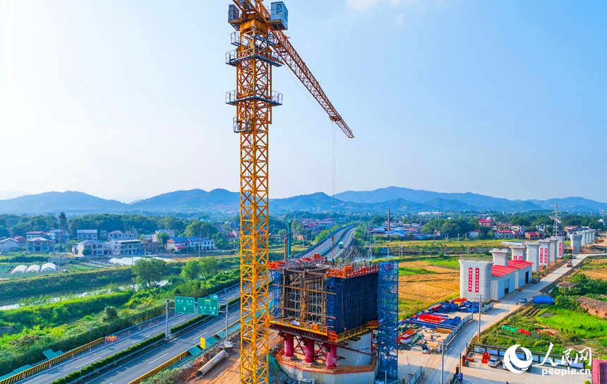 萍鄉市上栗縣金山鎮的栗水河特大橋建設現場，塔吊林立，工業作業繁忙，基樁澆筑有序推進。人民網記者 朱海鵬攝
