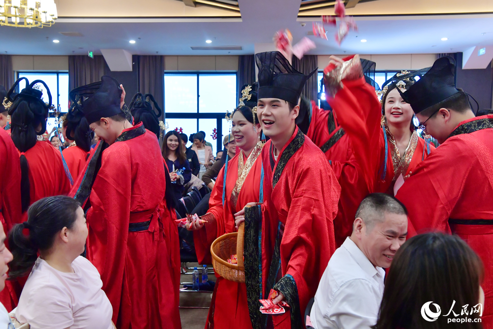 新人為參加集體婚禮的親朋好友分發喜糖。人民網記者 時雨攝