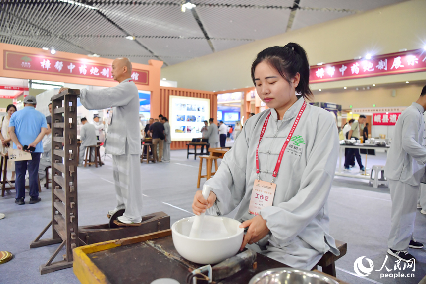 樟帮中药炮制技术展演现场，药工们用娴熟精湛的手法，为人们带来一场沉浸式中医药文化盛宴。人民网记者 时雨摄