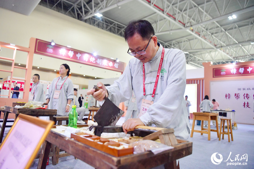 樟帮中药炮制技术展演现场，药工们用娴熟精湛的手法，为人们带来一场沉浸式中医药文化盛宴。人民网记者 时雨摄