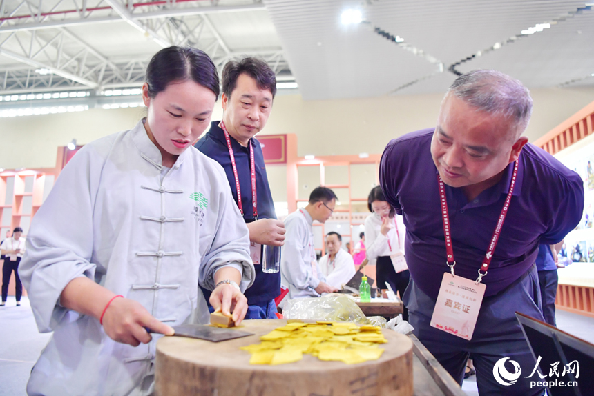樟帮中药炮制技术展演现场，药工们用娴熟精湛的手法，为人们带来一场沉浸式中医药文化盛宴。人民网记者 时雨摄