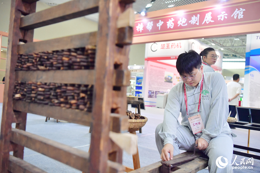 樟帮中药炮制技术展演现场，药工们用娴熟精湛的手法，为人们带来一场沉浸式中医药文化盛宴。人民网记者 时雨摄