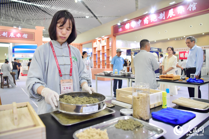 樟帮中药炮制技术展演现场，药工们用娴熟精湛的手法，为人们带来一场沉浸式中医药文化盛宴。人民网记者 时雨摄