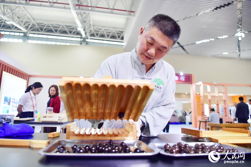 樟帮中药炮制技术展演现场，药工们用娴熟精湛的手法，为人们带来一场沉浸式中医药文化盛宴。人民网记者 时雨摄