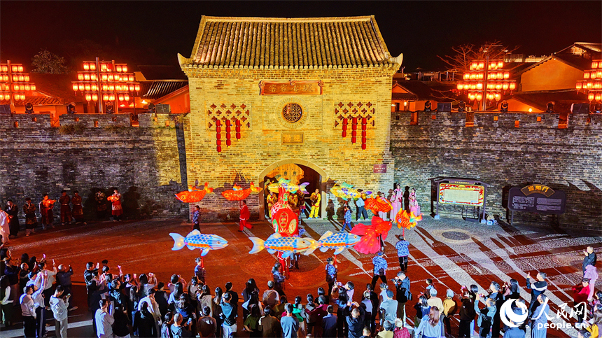 游客在赣州市定南县的客家古城游览，观看特色节目展演。人民网记者 朱海鹏摄