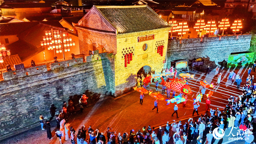 游客在赣州市定南县的客家古城游览，观看特色节目展演。人民网记者 朱海鹏摄