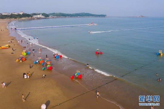 6月24日,游客在浙江省舟山市朱家尖南沙景区的沙滩上游玩(无人机
